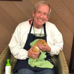 Don, a volunteer, holds guinea pig in a towel