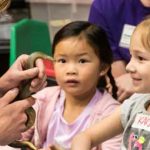 Children face small snake in classroom
