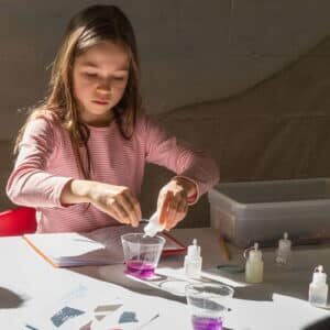 Child experiments with eyedropper and liquids